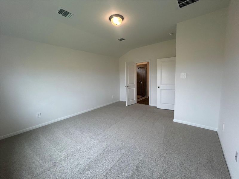 Spare room featuring carpet and vaulted ceiling Spare room featuring carpet and vaulted ceiling