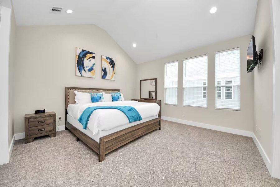 High ceilings and three windows give the primary bedroom an airy feel with plenty of natural light throughout the day.