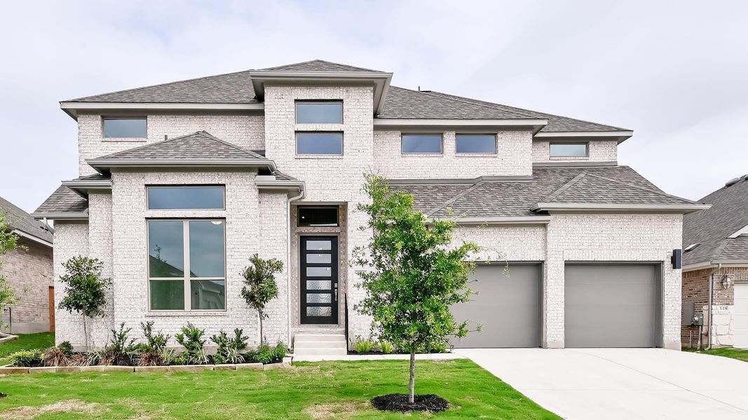 Prairie-style house featuring brick siding, driveway, a front yard, entry steps, and a shingled roof