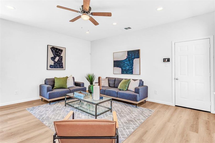 Living room with light hardwood / wood-style flooring and ceiling fan