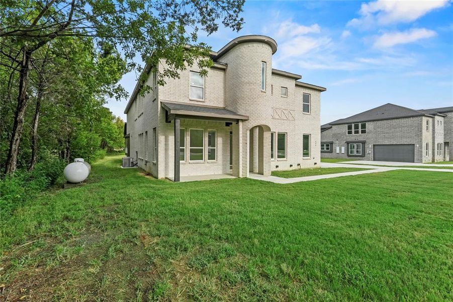 Rear view of house featuring brick siding, a yard, and a garage Rear view of house featuring brick siding, a yard, and a garage