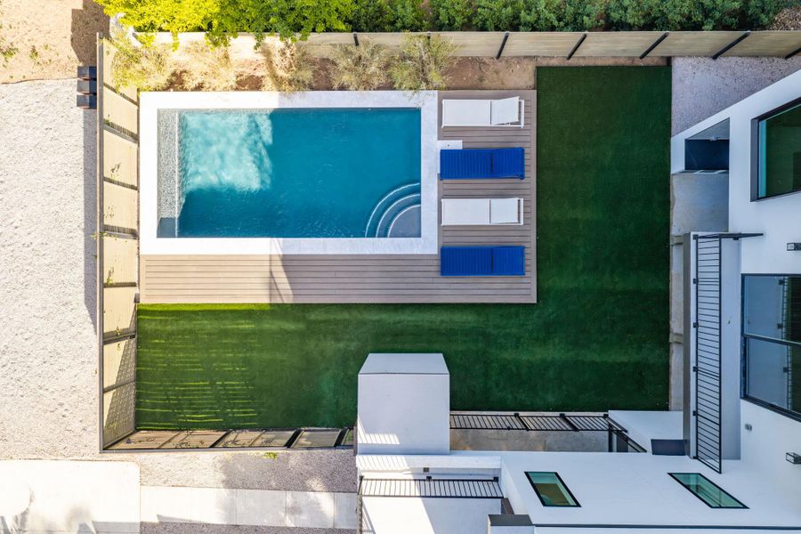 An aerial perspective showcases a sleek rectangular pool integrated with clean deck lines and lush lawn. An aerial perspective showcases a sleek rectangular pool integrated with clean deck lines and lush lawn.