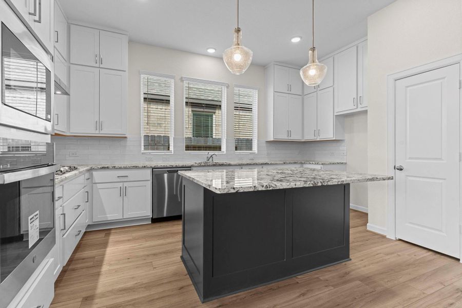 Gourmet kitchen with custom tall cabinets with sleek hardware and beautiful chic tile backsplash and more!