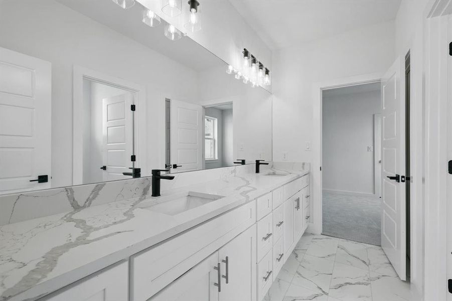 Bathroom featuring double vanity and marble finish floors