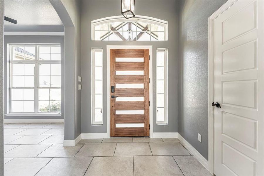 Tiled foyer featuring a healthy amount of sunlight and ornamental molding