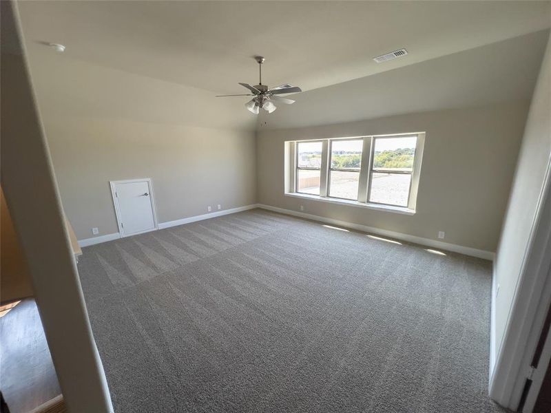 Unfurnished room featuring ceiling fan and carpet