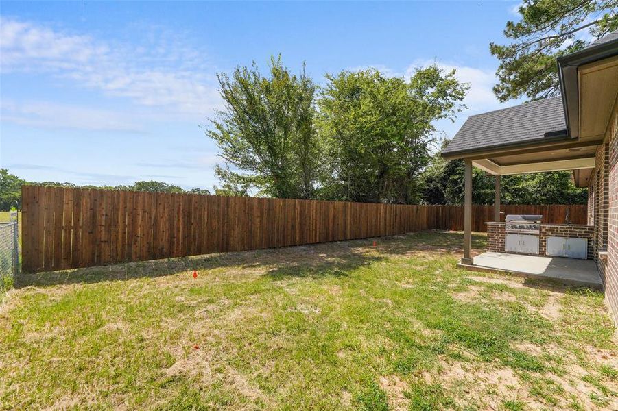 Spacious backyard featuring a new wood privacy fence