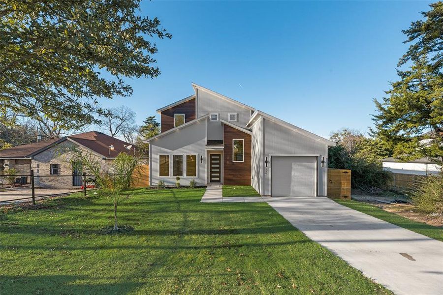 Contemporary home featuring concrete driveway and a garage Contemporary home featuring concrete driveway and a garage