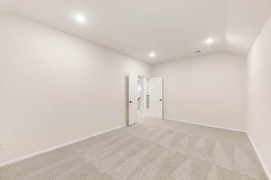 Empty room with gray carpet, white walls, recessed lighting, and double doors opening to hallway Empty room with gray carpet, white walls, recessed lighting, and double doors opening to hallway