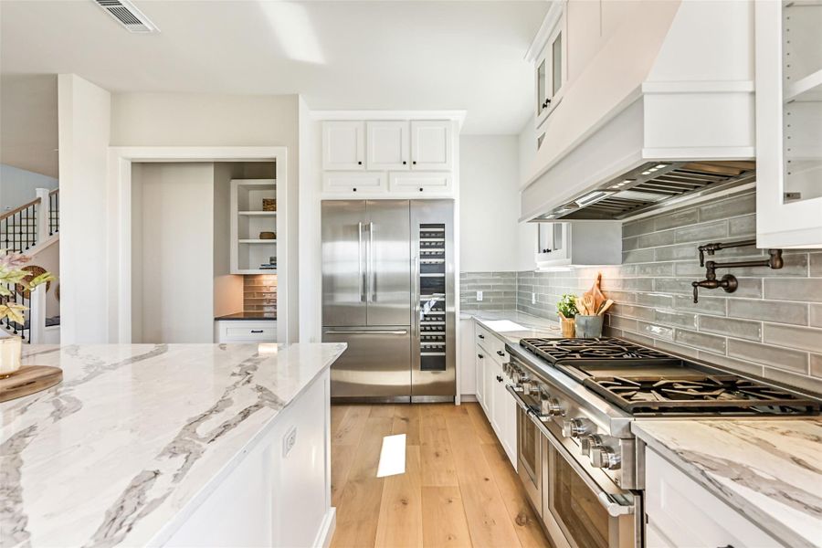 Stylish furnishings complement the luxurious finishes, creating a kitchen that is both a gathering place and a stage for everyday elegance. Picture lively breakfasts or quiet morning coffee with sun spilling through the windows.