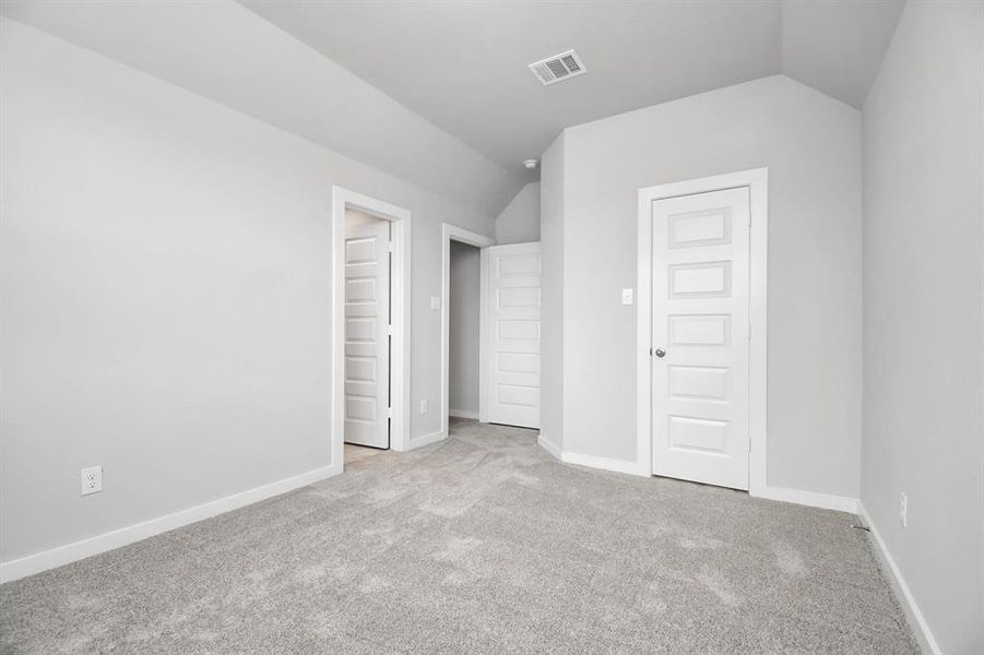 Secondary bedroom features plush carpeting, large windows that let in plenty of natural light, bright paint, and spacious closets. Sample photo of completed home with similar floor plan. Actual colors and selections may vary.