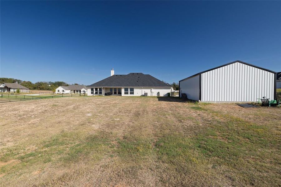 View of yard with a pole building, an outbuilding, and a patio area