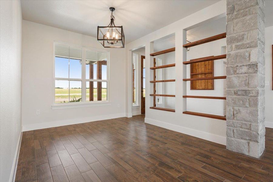 Bright interior space features decorative shelving and rich wood flooring.