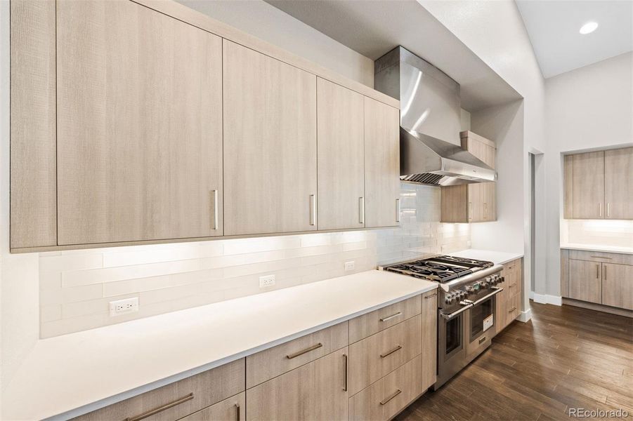 Custom kitchen cabinetry with undermount LED lighting, Thermador 6-burner plus griddle and double ovens, and Thermador stainless steel hood.