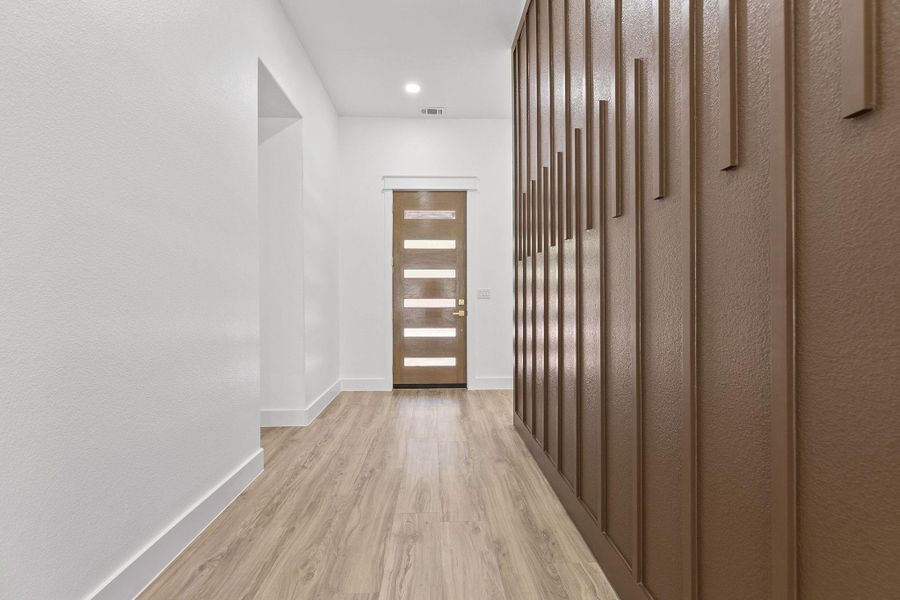 Doorway to outside with wood finished floors and baseboards