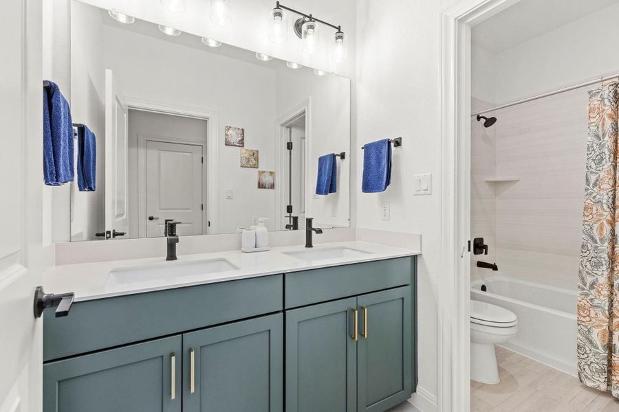 Full bath featuring double vanity and shower / tub combo with curtain