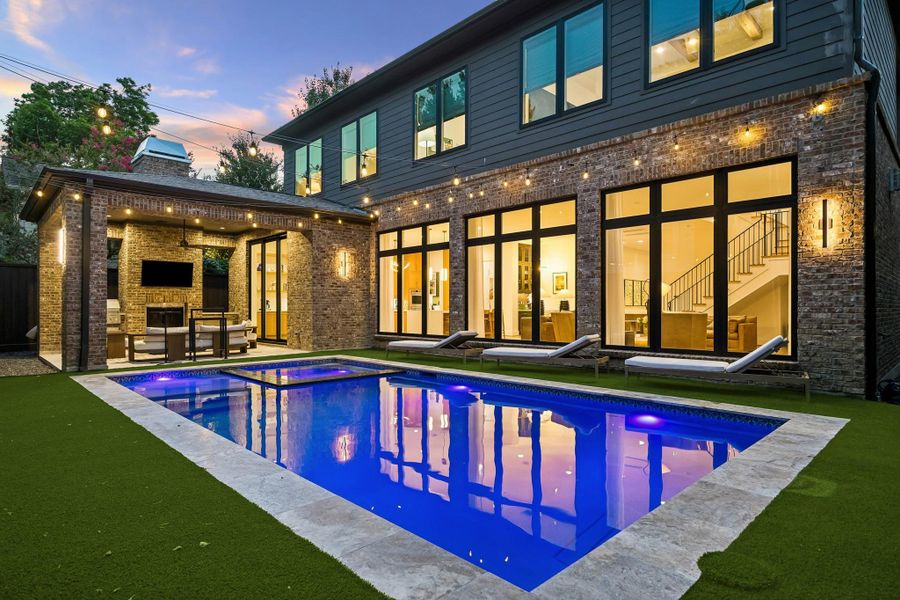 Imagine unforgettable summer days in this exceptional backyard, featuring a covered lanai, outdoor kitchen, and a stunning pool by Mirage Custom Pools.