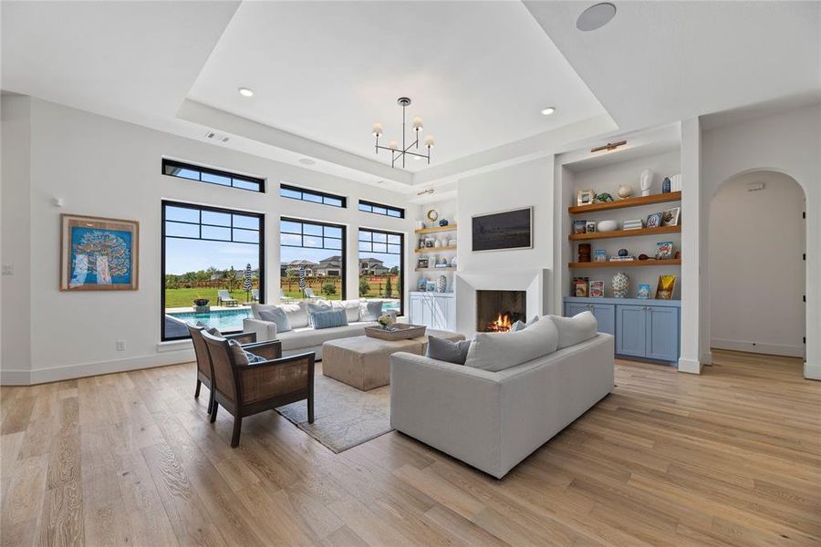 Now into the living space... this is what it's all about. Take in the soaring ceilings as natural light spills in from your beautiful wall of windows to beautifully frame in the pool and lake views.