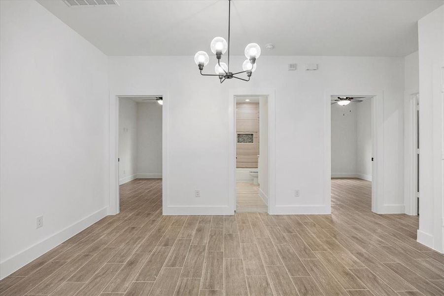 Unfurnished dining area featuring wood finish floors, a ceiling fan, and suspended lighting