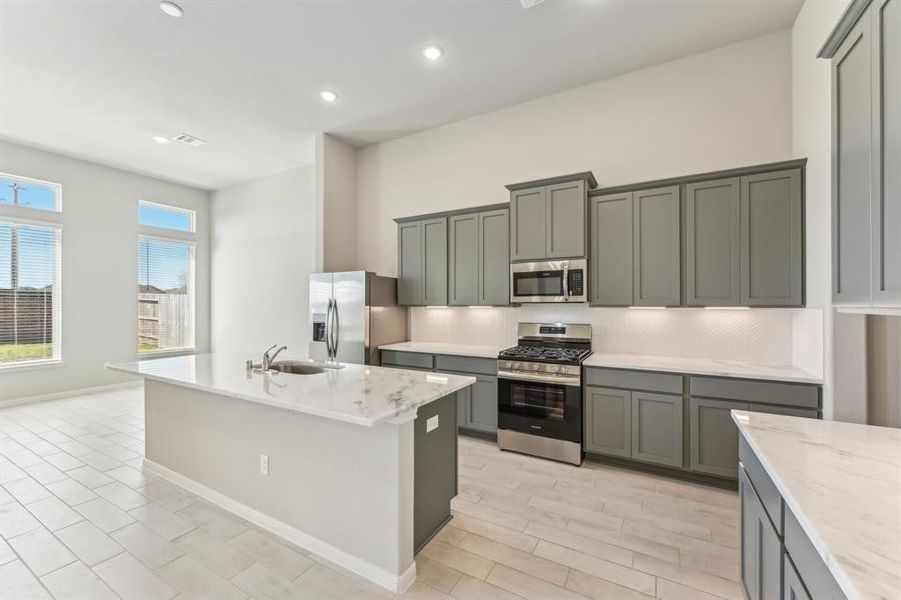 This stunning kitchen has modern cabinetry, sleek countertops, and stainless steel appliances.