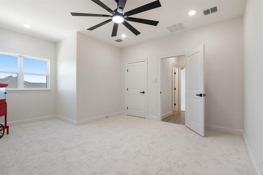 Unfurnished bedroom with light colored carpet, a ceiling fan, and recessed lighting Unfurnished bedroom with light colored carpet, a ceiling fan, and recessed lighting