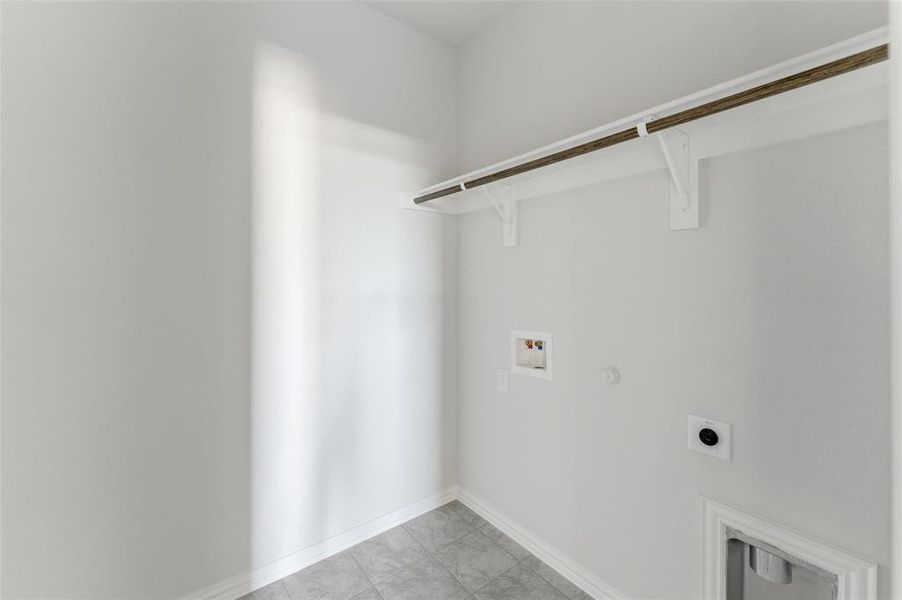 Laundry area featuring hookup for a gas dryer, hookup for a washing machine, electric dryer hookup, and light tile patterned flooring
