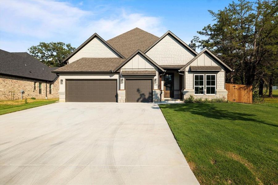 Craftsman inspired home featuring a garage and a front lawn Craftsman inspired home featuring a garage and a front lawn
