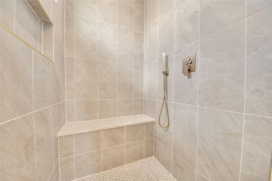 Primary bath walk-in shower with handheld faucet and seating bench. Primary bath walk-in shower with handheld faucet and seating bench.