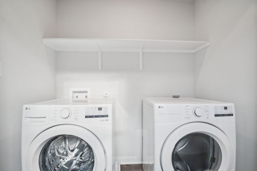 A white laundry room with a white washer and dryer.
