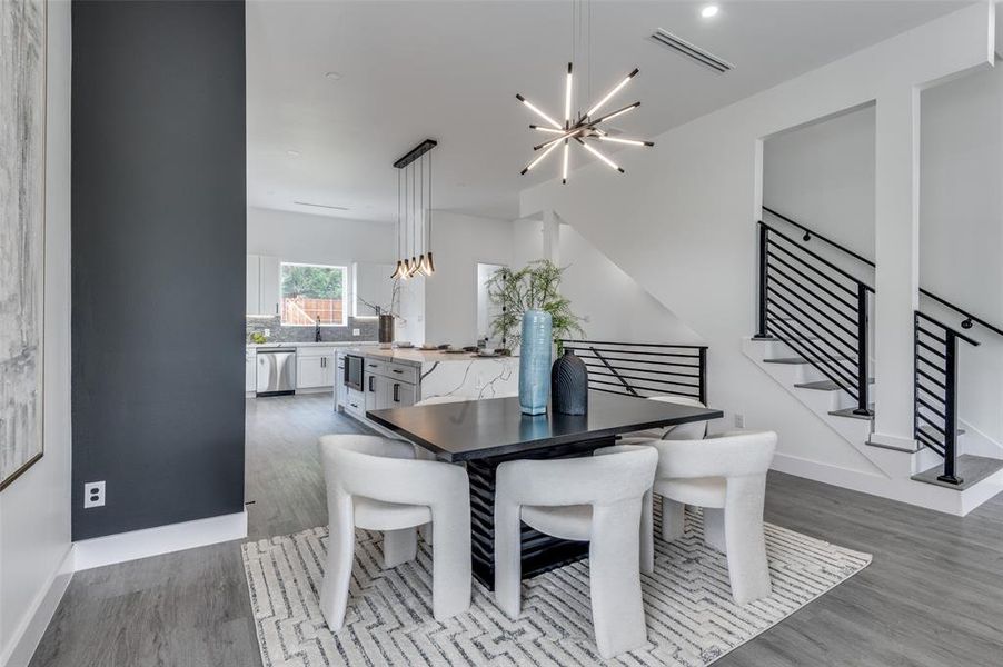 Dining area with hardwood / wood-style floors and an inviting chandelier