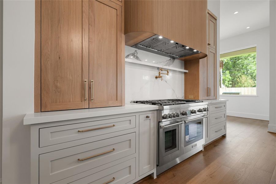 Above the Thermador stove is a pot filler and small shelf offering additional convienence.