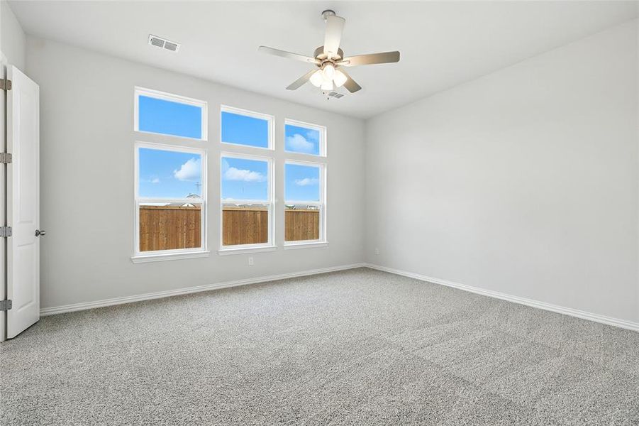 Empty room featuring light colored carpet and a ceiling fan Empty room featuring light colored carpet and a ceiling fan