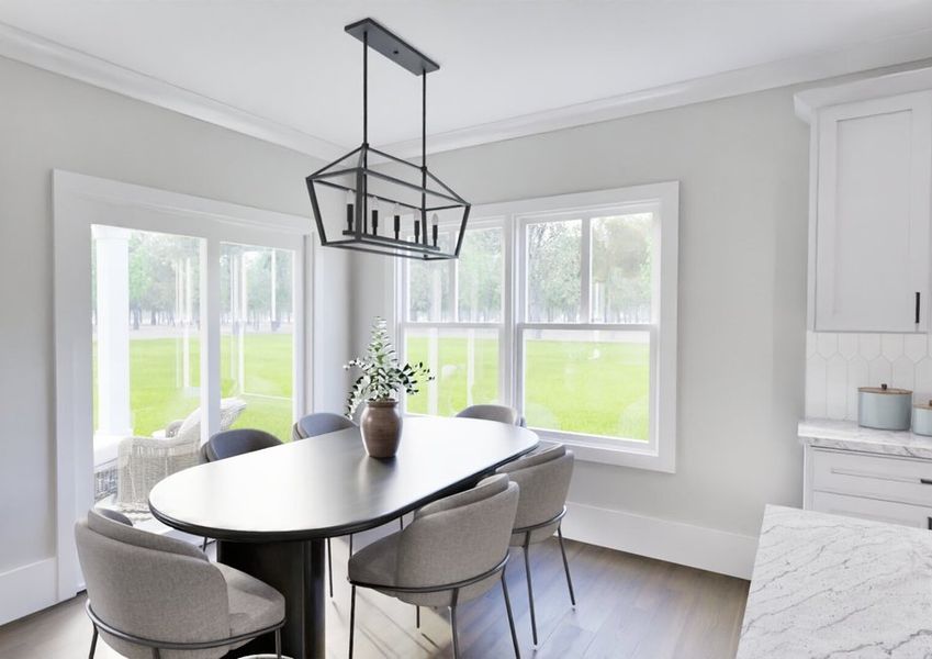A dining room featuring a table and chairs positioned in front of a large window, allowing natural light to enter.