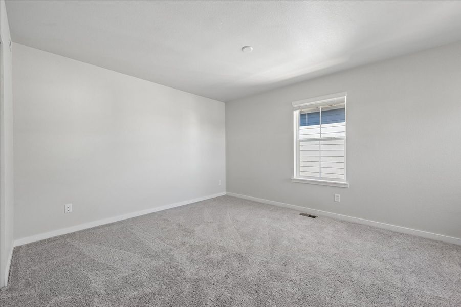 A room with a window and a carpet.