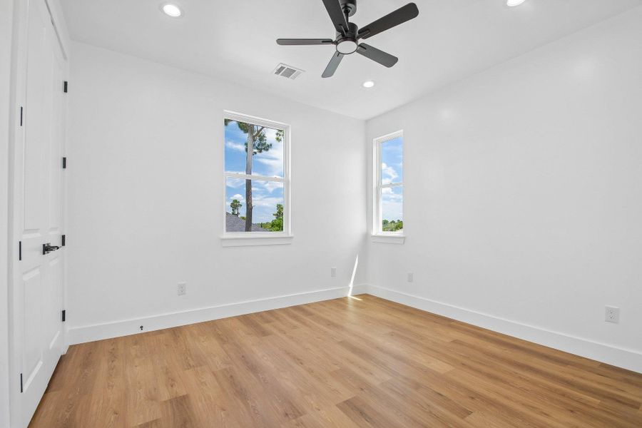 Warm wood flooring and clean white walls anchor this versatile secondary bedroom space. Warm wood flooring and clean white walls anchor this versatile secondary bedroom space.