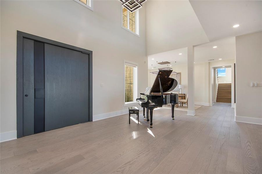 Entryway featuring recessed lighting, wood finished floors, and a high ceiling Entryway featuring recessed lighting, wood finished floors, and a high ceiling