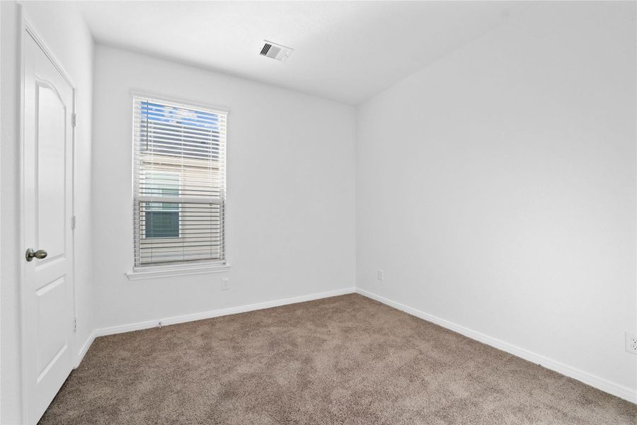 On the first floor, this secondary bedroom offers comfort and style with plush carpeting, neutral paint tones, recessed lighting, a large window with blinds, and a walk-in closet. On the first floor, this secondary bedroom offers comfort and style with plush carpeting, neutral paint tones, recessed lighting, a large window with blinds, and a walk-in closet.