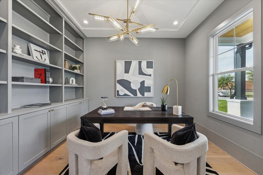 Quiet first-floor office with built-ins, a large window, and a modern light fixture—an ideal work-from-home space.