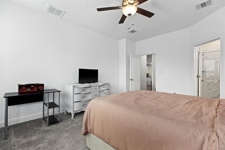 Bedroom with carpet flooring, ceiling fan, and ensuite bathroom