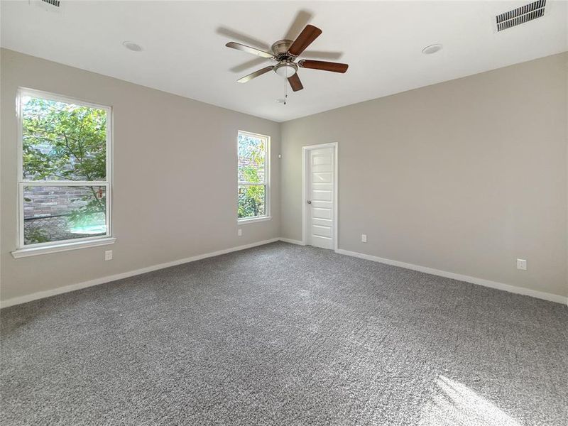 Carpeted spare room with baseboards and a ceiling fan