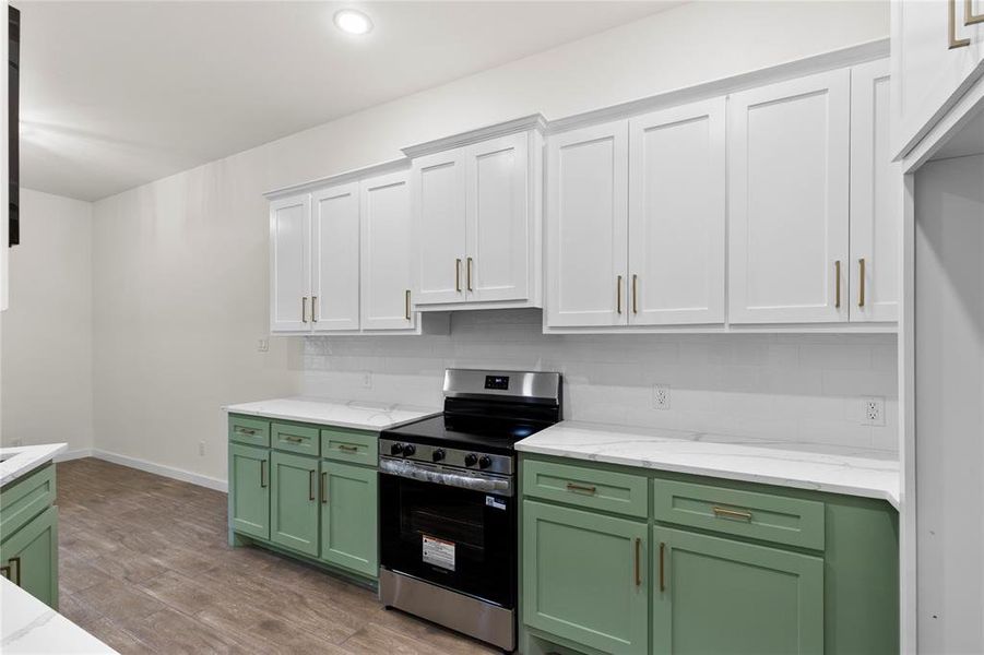 Modern kitchen featuring two-tone cabinetry with white upper cabinets and sage green lower cabinets