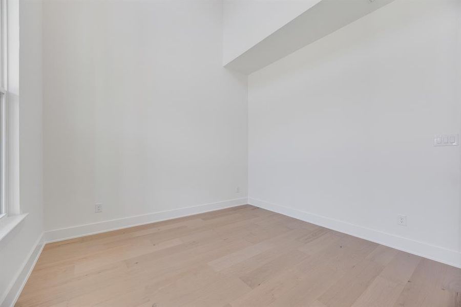 Spare room featuring light wood-type flooring and baseboards