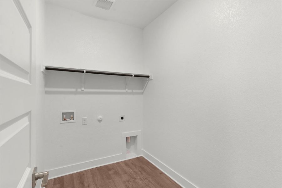 Laundry room with gas dryer hookup, dark wood-type flooring, washer hookup, and electric dryer hookup Laundry room with gas dryer hookup, dark wood-type flooring, washer hookup, and electric dryer hookup