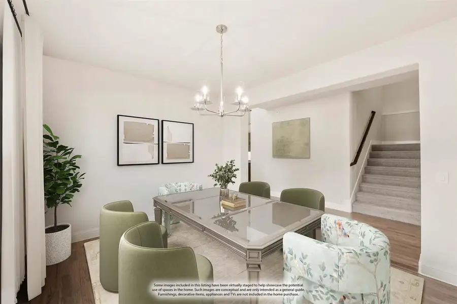 Dining room with glass-top table, green chairs, chandelier, and staircase visible in background