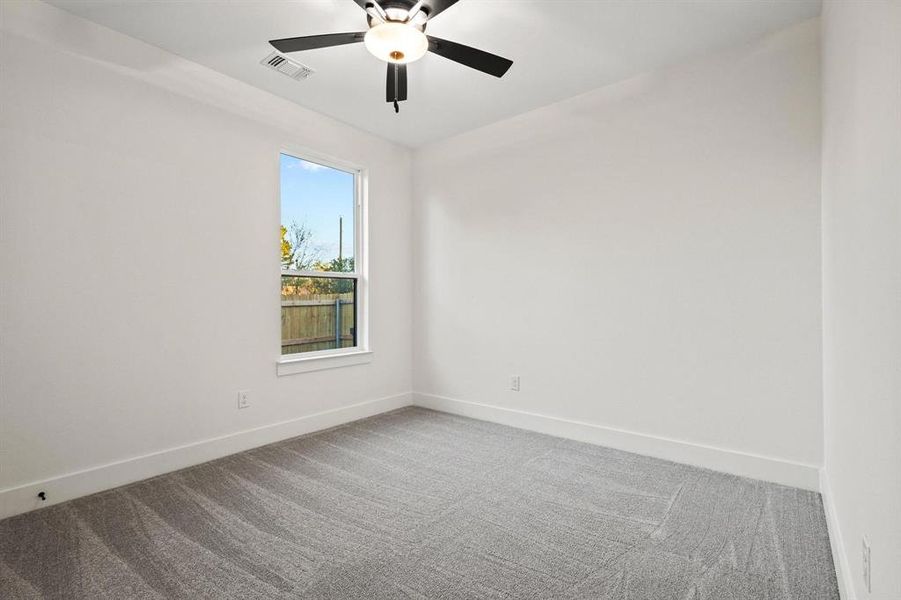 Empty room with carpet flooring and a ceiling fan