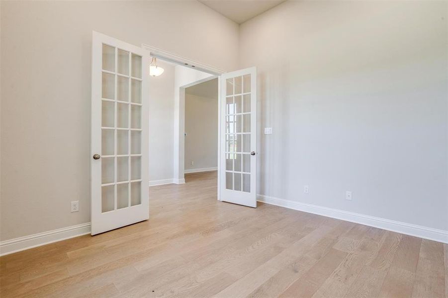 Spare room with light wood-type flooring and french doors