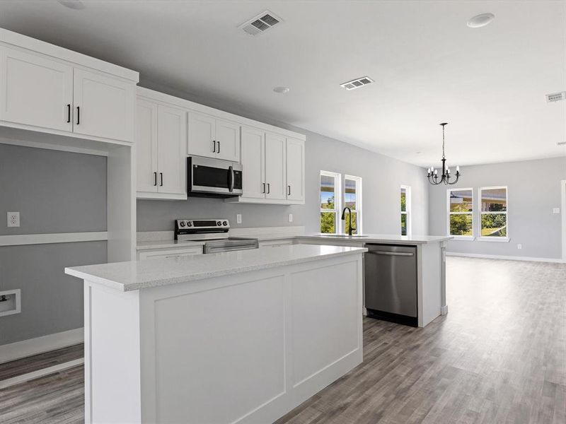 Kitchen featuring stainless steel appliances, a center island, a peninsula, light wood-type flooring, and recessed lighting