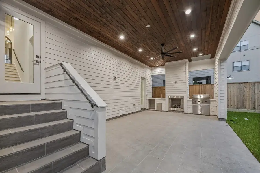 Large covered Lanai with a Gas Fireplace, Stainless Steel Grill, Stainless Steel Sink, Slab Quartz Counter and Electrical Connection for a Beverage Center.  The Lanai ceiling is finished with Tongue and Groove Stained Wood and a Ceiling Fan. The patio floor is completed with a stamped smooth texture concrete.
