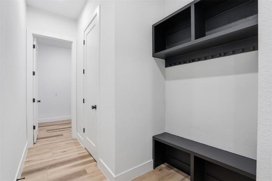 Built-in organizational system featuring dark shelving, storage cubbies, and coat hooks