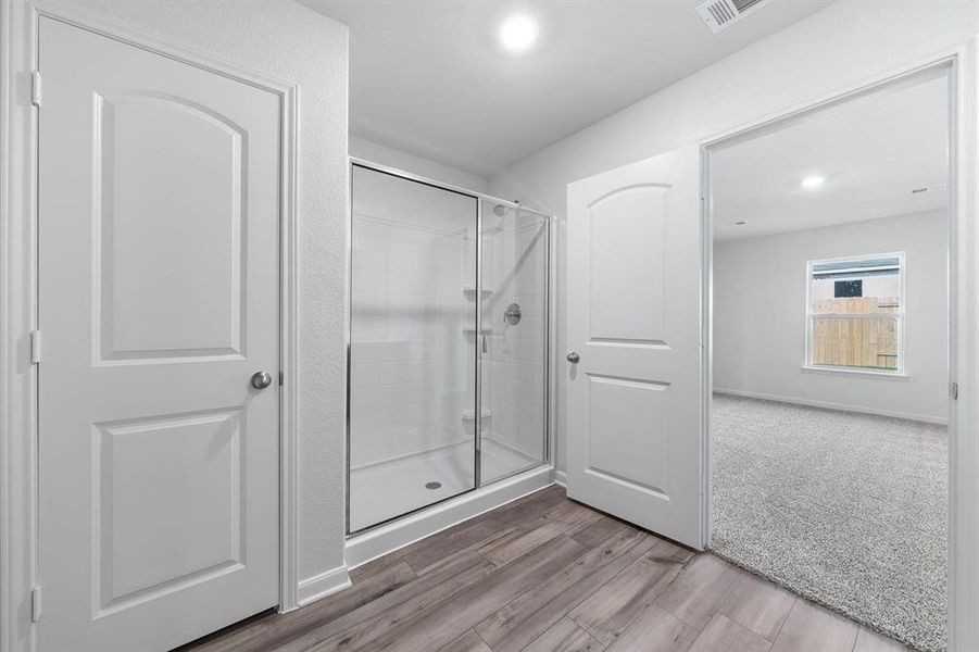 Bathroom featuring a shower with door and hardwood / wood-style flooring